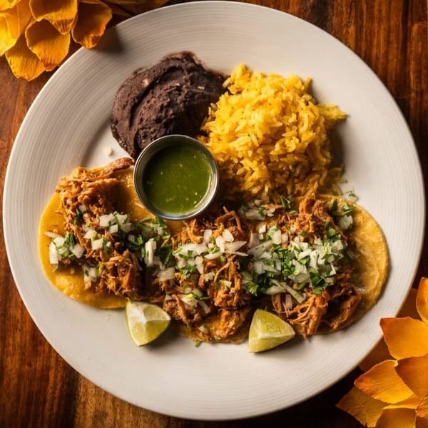 Ofrenda's Mexican tacos with shredded meat, onions, cilantro, lime, rice, and refried beans.