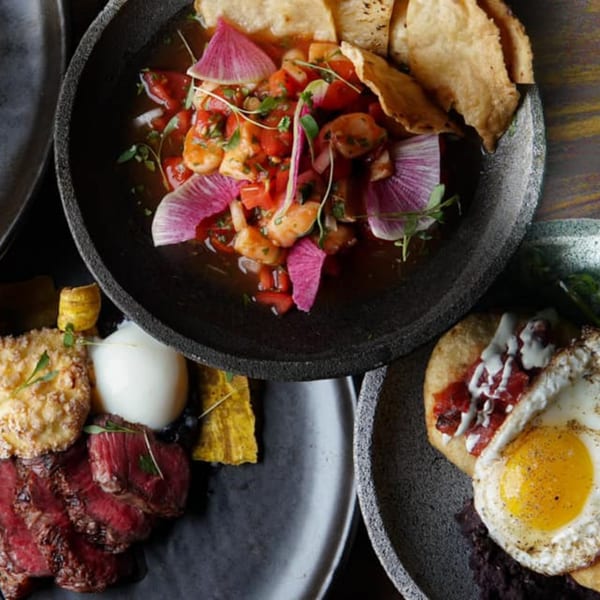 Three Mexican dishes: ceviche with chips, sliced steak with a white dollop, and a fried egg on a tortilla.